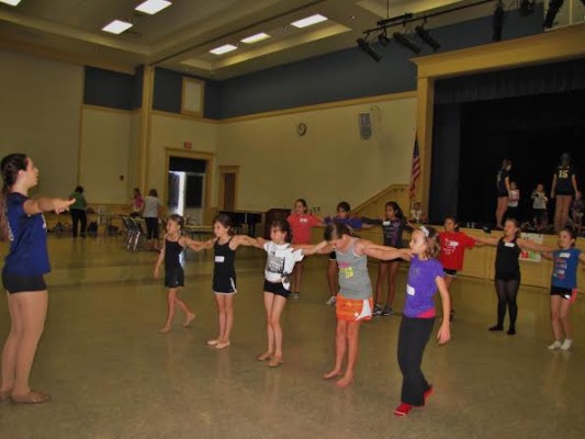 Sophomore Kelsea Henry teaches the little girls how to be in a kick line. 