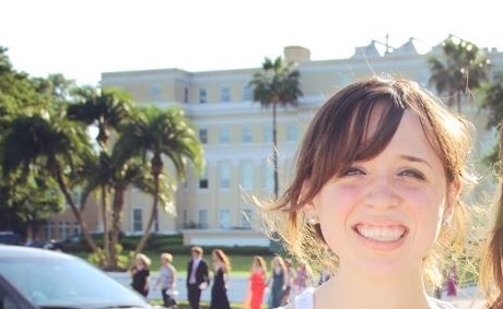 Gracie Hancock is proud to help better the energy of her school. Gracie smiles in front of her beautiful school, Academy of the Holy Names