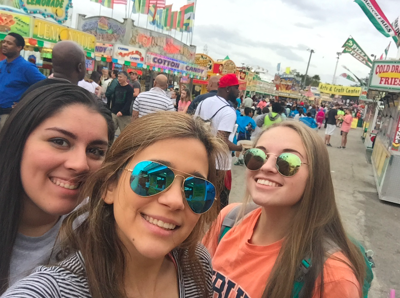 Alejandra Lozano, Alma Torres and Karlee Nipper pose with all the vendors at the State Fair after getting some fried oreos!