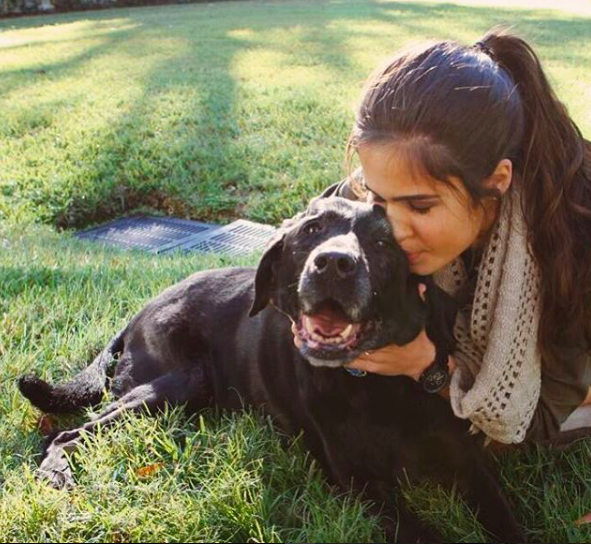 Senior Isabella Alfonso poses with her pup as he smiles at the camera. 
Credit: Isabella Alfonso/Achona Online