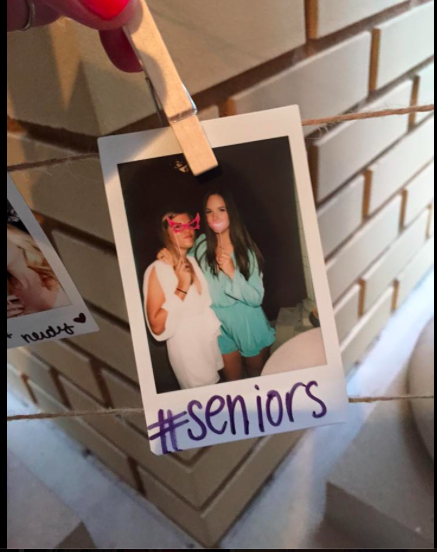 Seniors Lindsay Boos and Kelsea Henry taking pictures at a photo booth at a  graduation party last year 