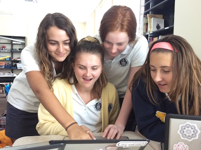 Sophomores Gloria Bufano,  Rebekah Eicholtz, and Isabella Leandri crowd around Juliana Jett and her laptop to watch Simone Biles' vault performance in the Vault Finals in Rio.