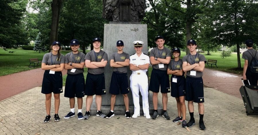 Olivia Perez (20) and her squad pose outside of Bancroft Hall with a current USNA student. 