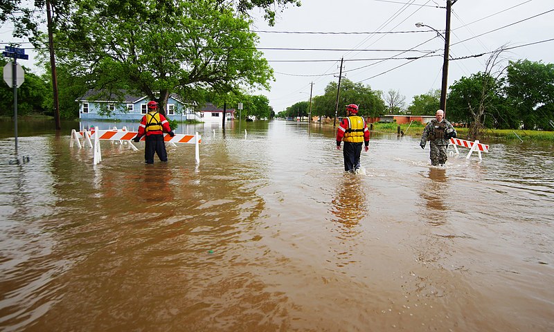 Texas Guardsmen and Texas Task Force 1 rescue personnel wade through thigh-deep water to  help stranded residents back to rescue vehicles during severe flooding in Wharton, Texas, April 21, 2016. In coordination with Texas Task Force 1 and the City of Wharton emergency services, a detachment from Delta Company of the 536th Brigade Support Battalion, Texas Army National Guard deployed several Light Multi-terrain Vehicles to floodwaters rescuing both people and pets. (U.S. Army National Guard photo by 1st Lt Zachary West)