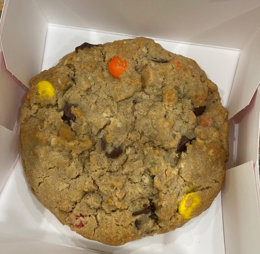Crumbl Cookies describes this cookie as “A warm peanut butter oatmeal cookie with M&MS®, creamy peanut butter chips, and rich semi sweet chunks.” 