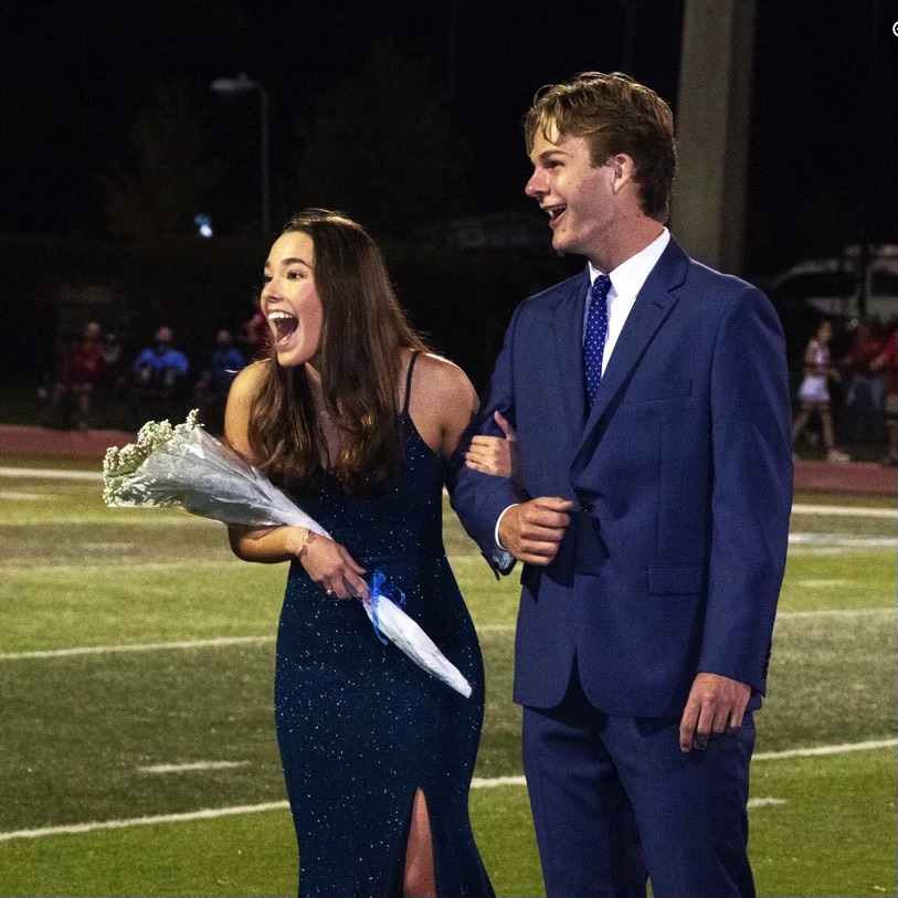 Mary Grace Nash (12) stands in the spotlight in the Jesuit football field after hearing her name be announced as homecoming queen.
