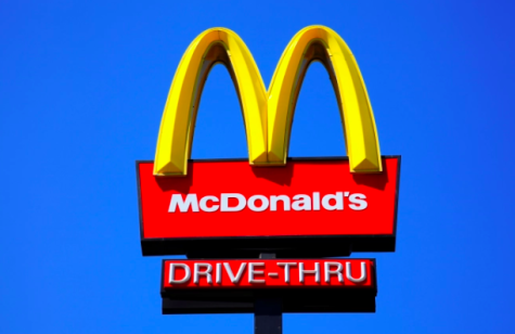 McDonalds drive-thru logo stand attracts customers to the fast-food stop.