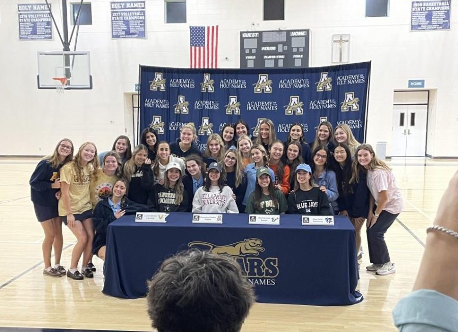 The signees smile while they are gathered by all their friends!