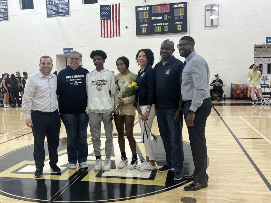 Basketball senior Jayda Pinder stands with her family at the center of the court before the match versus River Ridge High School begins. She is joined by her coaches and teammates during the evening of recognition! 