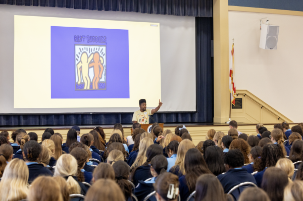 Speaker Joshua Felder talking to crowd about his experiences with Best Buddies and his multifaceted career.