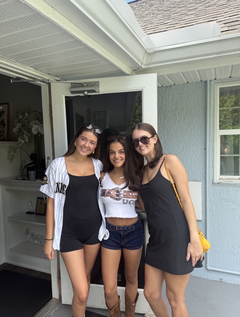 Peyton Pickett (A'25), Olivia Vargas (A'25), and Ali Ibanez ('26) take a photo before tailgating at UCF.